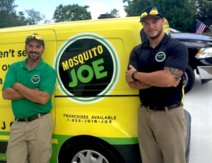 Two Mosquito Joe team members standing in front of a Mosquito Joe transit van.